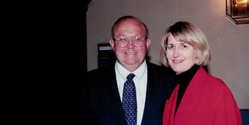 Vintage photograph of a man in a suit with a tie and a woman in a red coat, representing the early days of Fischer Homes.