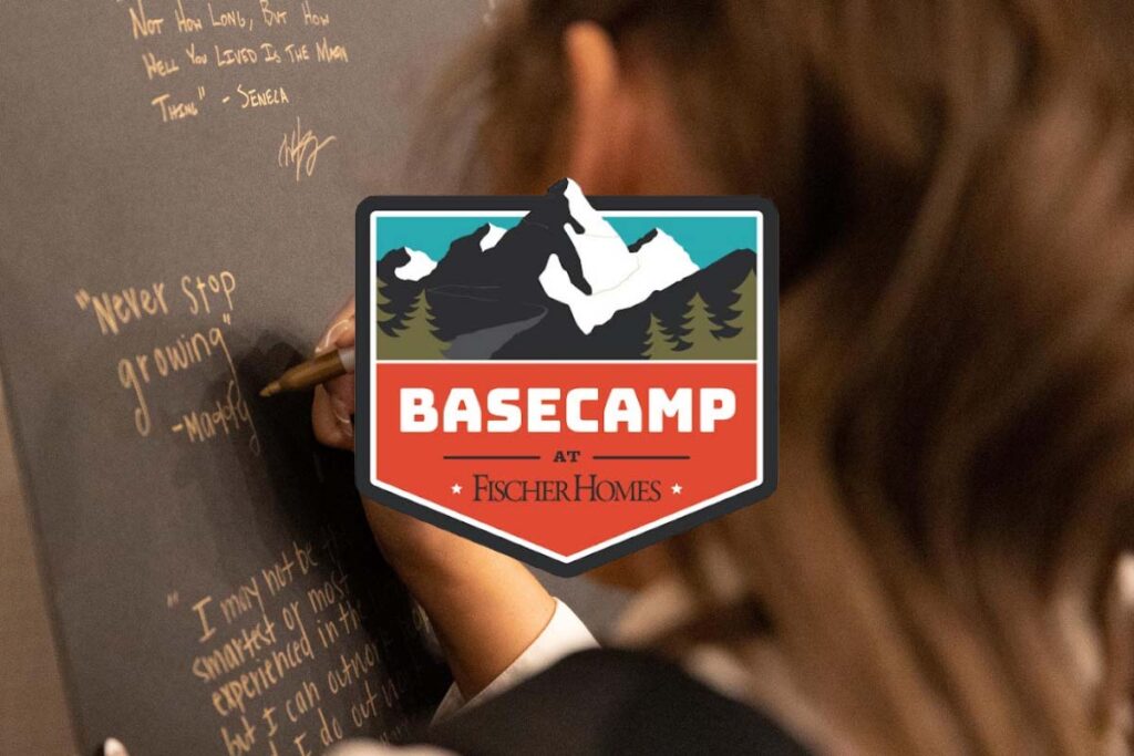 Basecamp at Fischer Homes logo overlay on a close-up of a person writing inspirational quotes on a chalkboard.